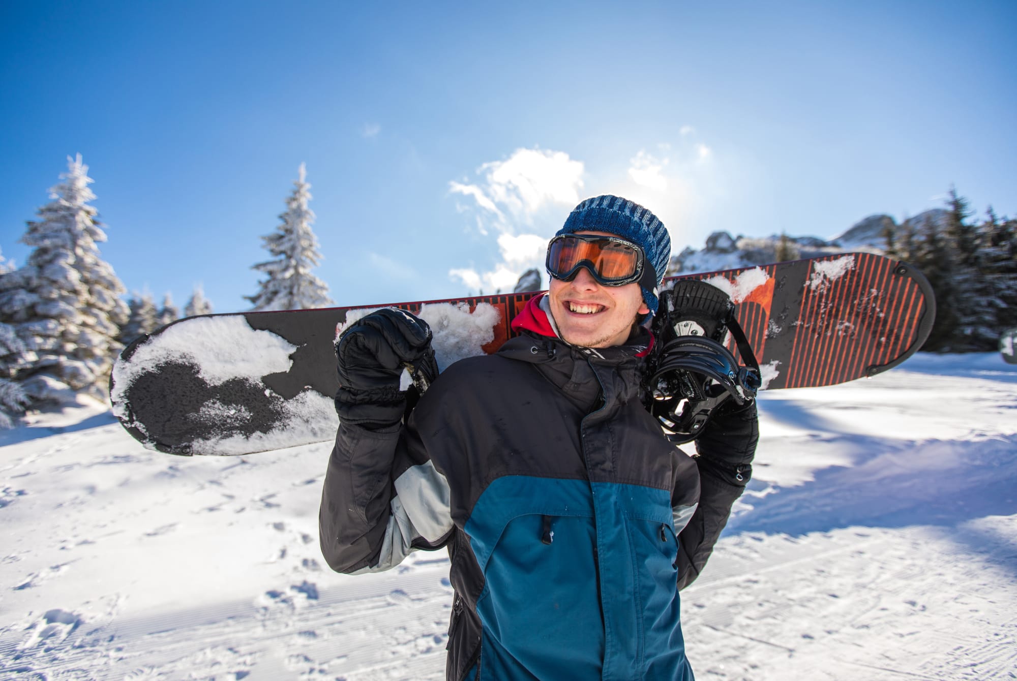 Man carrying snowboard on his back.