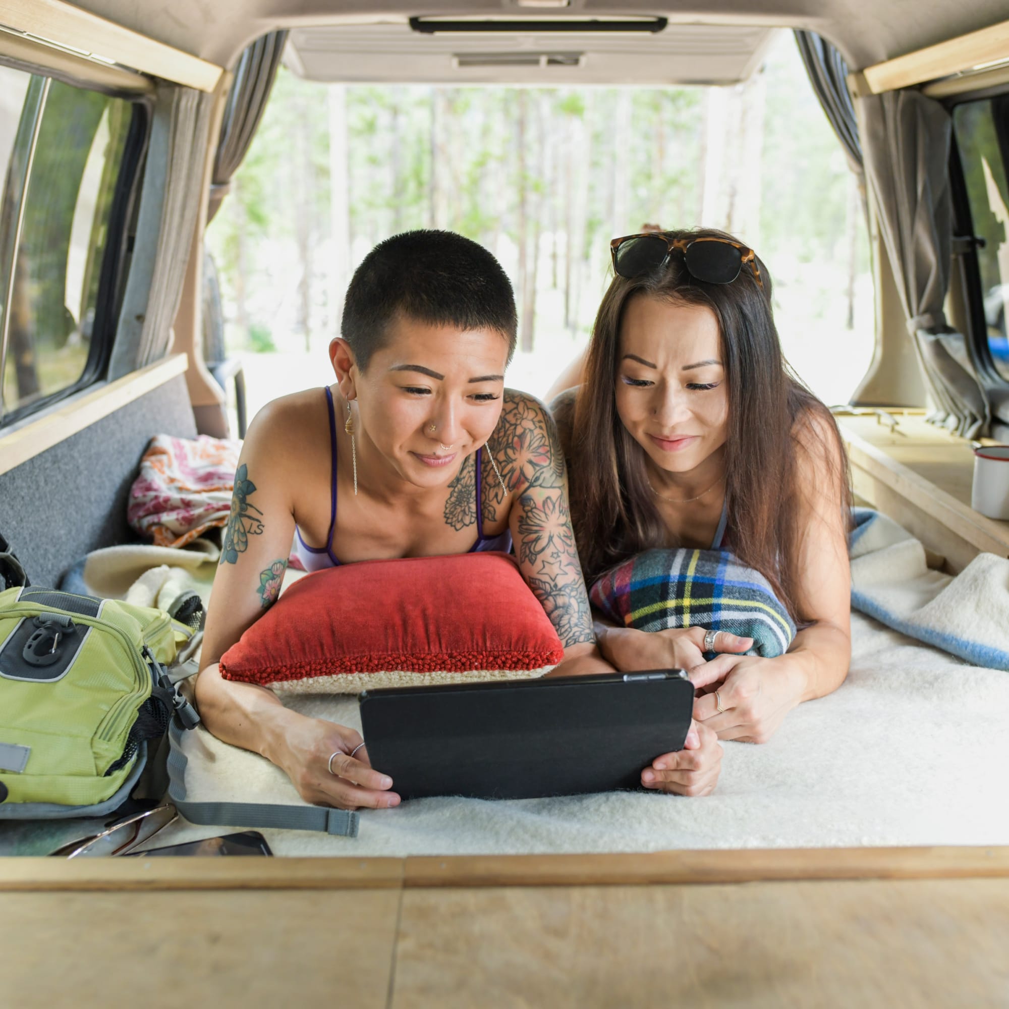 Two girls in a campervan looking at a tablet.